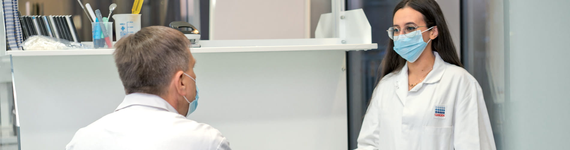 Two scientist discussing, document zone in a lab, laboratory, iPad, mobile device, mask, wearing masks, labcoat